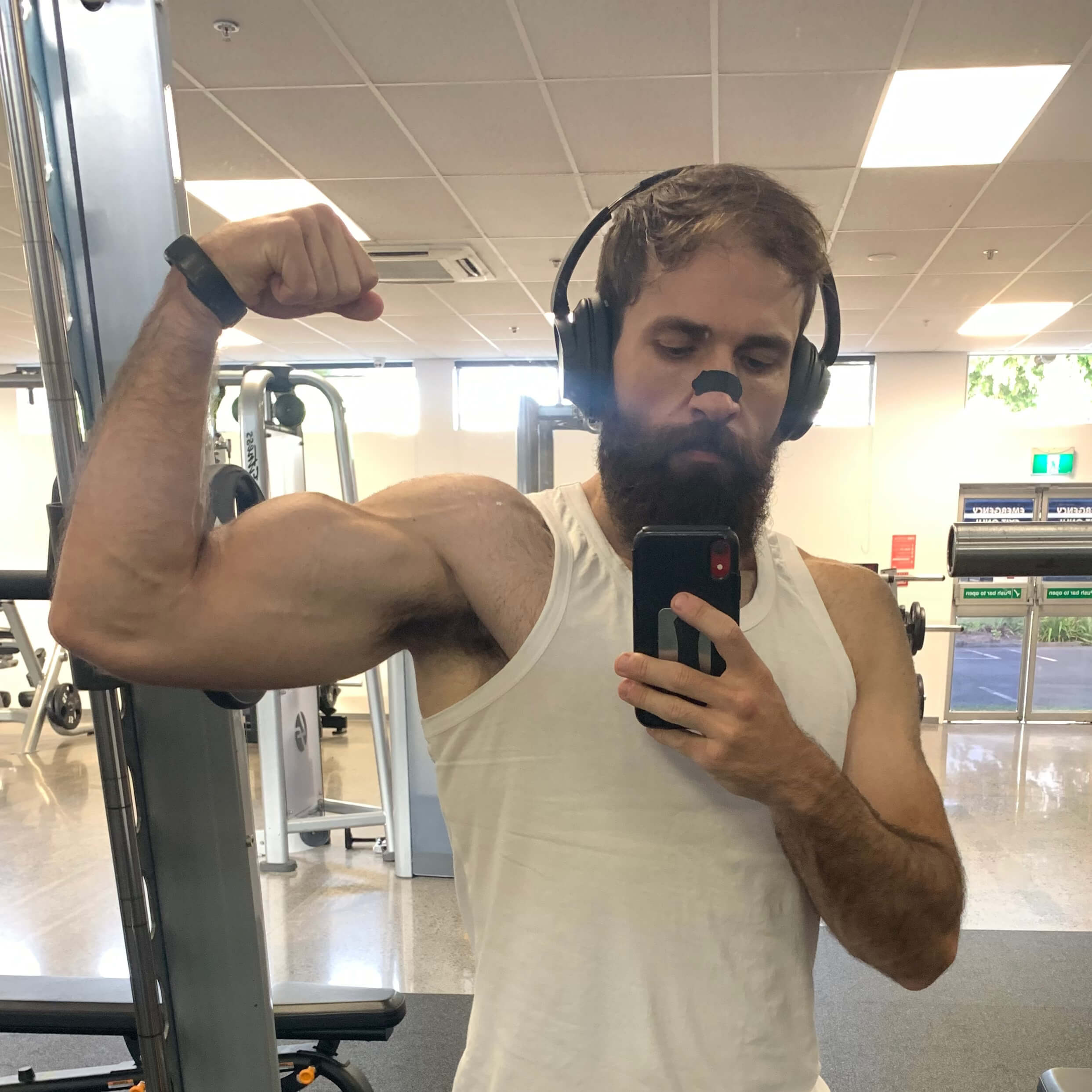 A current photo of BREATHMODE founder Jozef Wright at the gym wearing a black BREATHMODE nasal strip looking fit, strong, healthy and rested after discovering nasal strips.