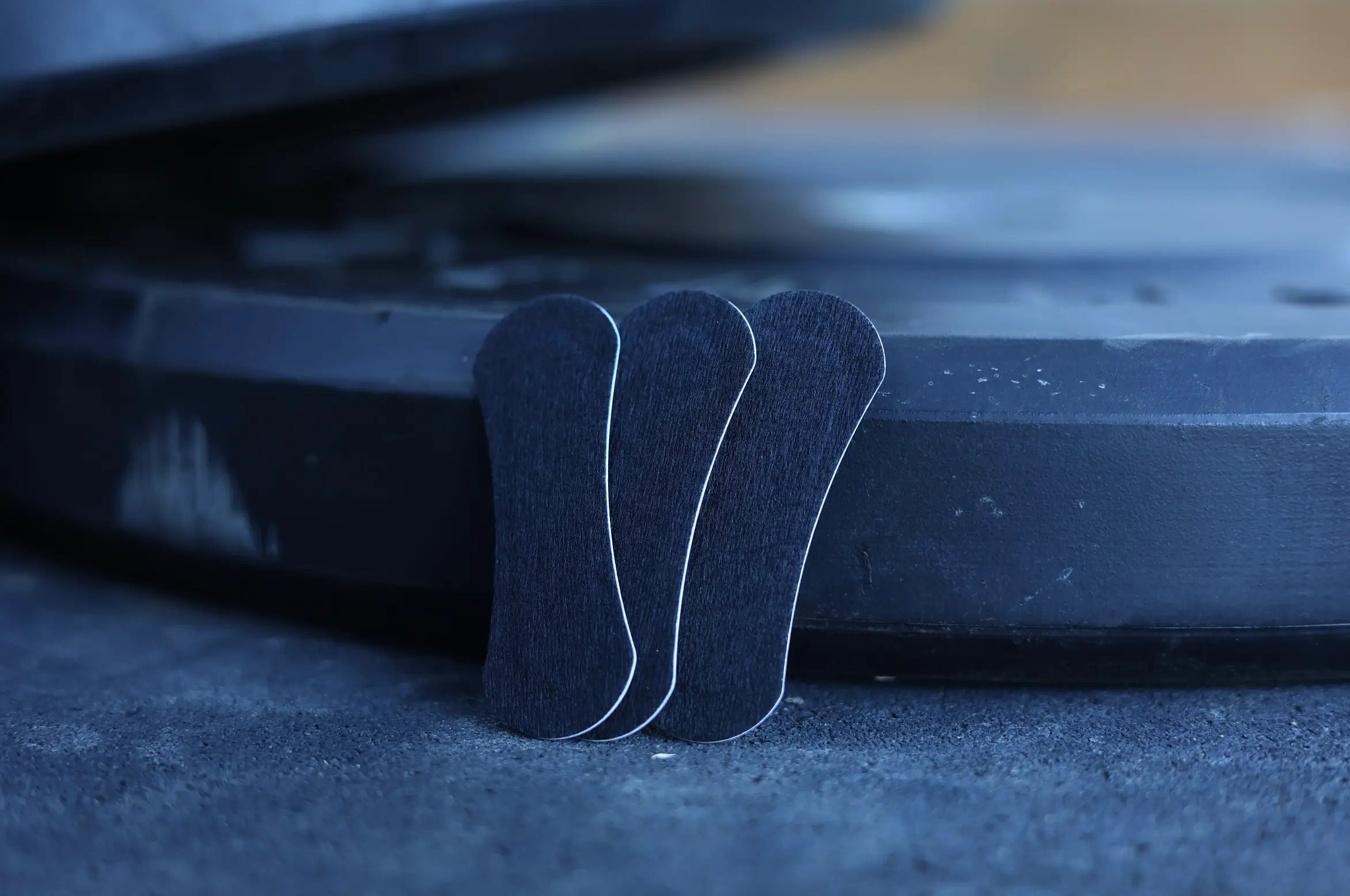 Three black BREATHMODE performance nasal strips leaning against bumper plates