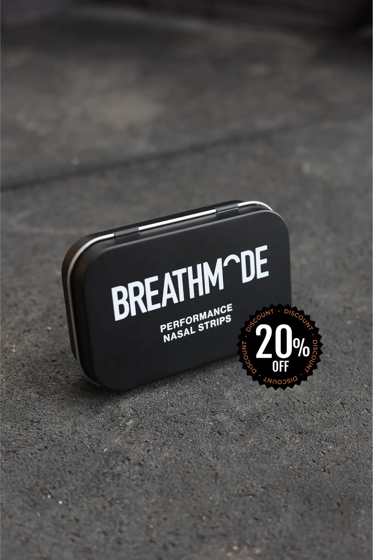 Black tin box with 'BREATHMODE' branding and a discount badge on a gray surface