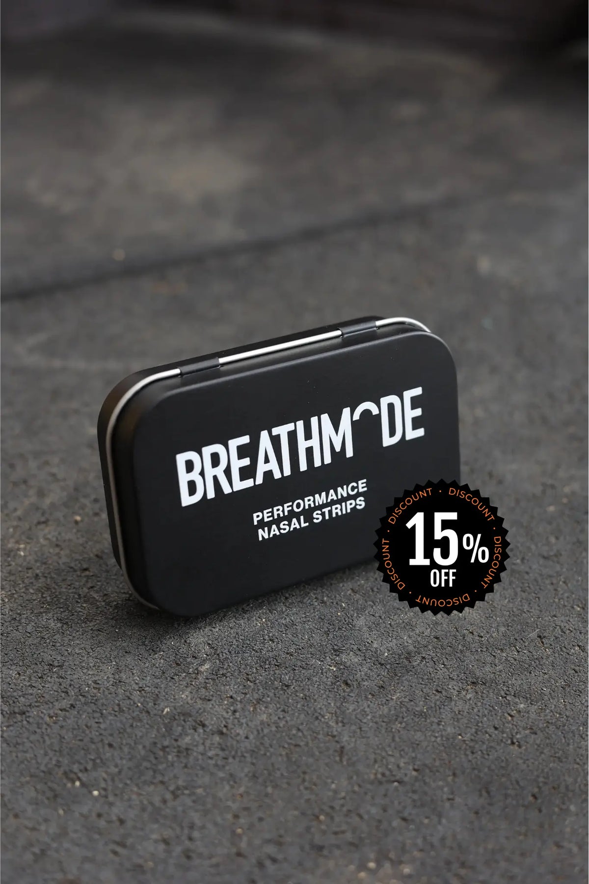 Black tin box with 'BREATHMODE' branding on a gray surface
