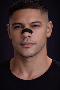 Headshot of an athlete wearing a black BREATHMODE performance nasal strip