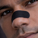 Close-up of an athlete wearing a black BREATHMODE performance nasal strip.