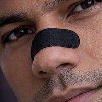 Close-up of an athlete wearing a black BREATHMODE performance nasal strip.